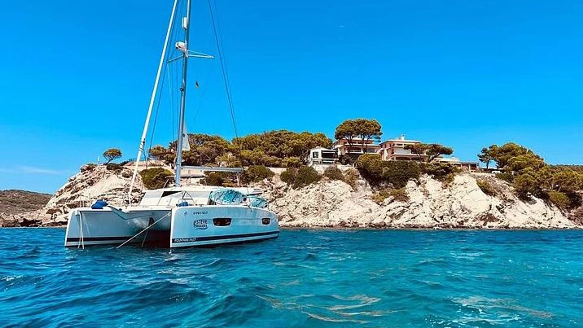 Catamaran sailing off Tenerife's volcanic south coast — SailTenerife